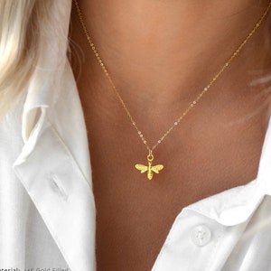 May include: A gold-filled necklace with a small bee pendant. The necklace is 16 to 18 inches long.