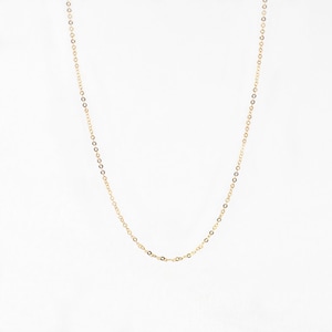 May include: A delicate gold-colored chain necklace. The necklace features small, evenly spaced links that create a subtle, elegant design. The chain is displayed against a plain white background, highlighting its simple beauty.