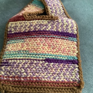 Conjunto de gorro y babero de crochet neutro para bebé en color burdeos cálido de Nylo & Co.