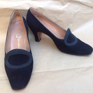 Peut inclure: Paire de chaussures à talons en daim noir avec un bout arrondi et un détail ovale décoratif sur le vamp. Les chaussures sont étiquetées "BELTRAMI" sur la semelle intérieure.