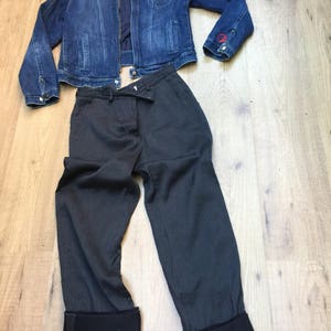 Peut inclure: Une veste en jean bleu fonc&eacute; avec une fermeture &eacute;clair rouge et un pantalon ray&eacute; gris fonc&eacute; avec des revers noirs.