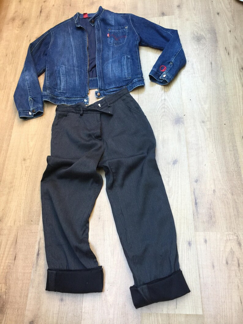 Peut inclure: Une veste en jean bleu fonc&eacute; avec une fermeture &eacute;clair rouge et un pantalon ray&eacute; gris fonc&eacute; avec des revers noirs.