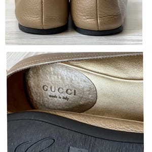 K&ouml;nnte beinhalten: Ein Paar goldene Gucci-Ballerinas aus Leder mit dem Markennamen und "Made in Italy" auf der Innensohle.