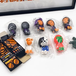 Peut inclure: Une collection de dix petites figurines en plastique colorées. Les figurines sont dans différentes poses et comprennent un singe, un chien, une grenouille et un oiseau. Les figurines sont emballées dans des sacs en plastique transparents.