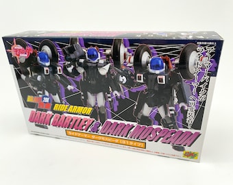 May include: A box for a toy robot set featuring two black and white robots with blue helmets. The box has a purple and black background with Japanese text that reads "Brave 20X Ride Armor Dark Bartley & Dark Mospearda".