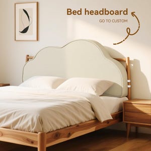 May include: Cream-coloured, cloud-shaped upholstered headboard on a wooden bed frame. The bed is made with white bedding and pillows. The text "Bed headboard" and "GO TO CUSTOM" are visible.