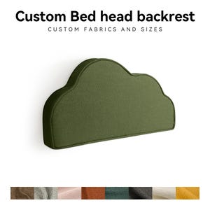 May include: Olive green cloud-shaped bed head backrest. The headboard is made of a textured fabric and is mounted on a white wall. The text "Custom Bed head backrest" and "Custom fabrics and sizes" is at the top of the image.