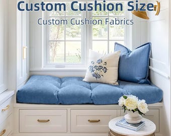 Könnte beinhalten: Eine Fensterbank mit blauem Kissen und Kissen. Ein weißes Kissen mit blauer Blumenstickerei ist auf dem Sitz zentriert. Der Text "Custom Cushion Size" und "Custom Cushion Fabrics" befindet sich oben im Bild.