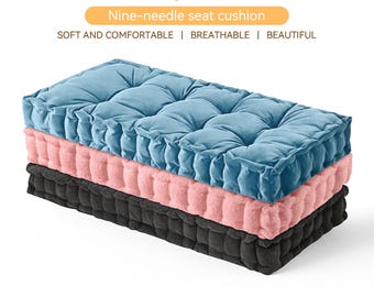 May include: Three long seat cushions stacked on top of each other. The top cushion is a light blue, the middle is pink, and the bottom is black. The cushions have a tufted design. Text at the top reads "Custom long seat cushion" and "Nine-needle seat cushion."
