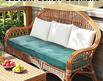 Puede incluir: Un banco de mimbre con un cojín de color turquesa y tres almohadas blancas. El banco está en un porche con una mesa de madera y fruta en un cuenco.