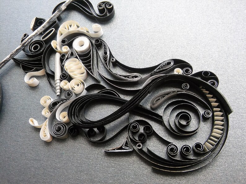 May include: Black and white paper quilling art, featuring intricate swirls and patterns. The design resembles a stylised motorcycle.
