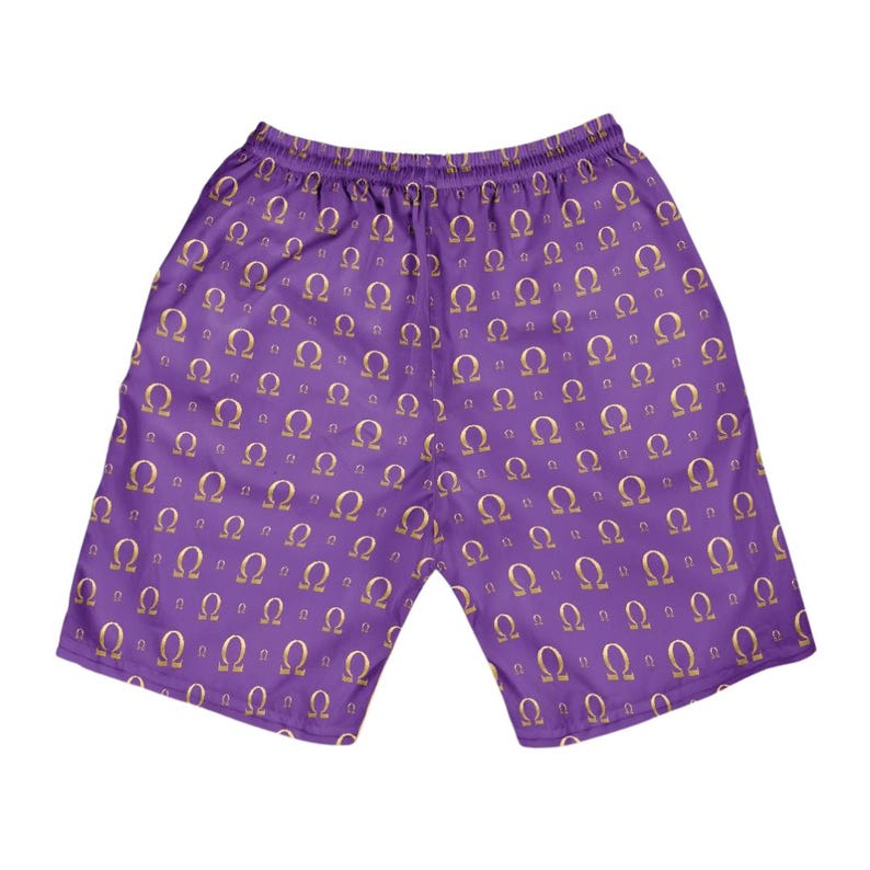 May include: Purple athletic shorts featuring an all-over repeating pattern of the Greek letter Omega in a metallic gold color. The shorts have an elasticized waistband and a loose, relaxed fit, showcasing a consistent print across the fabric.