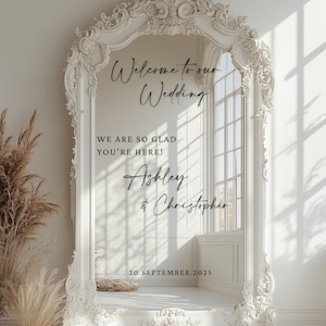 May include: A white ornate wedding sign with the text "Welcome to our Wedding", "We are so glad you're here!", and the names "Ashley & Christopher" along with the date "20 September 2025". The sign is framed by an elaborate, decorative border.