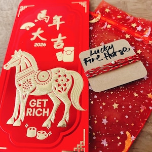 May include: A red envelope with gold Chinese characters and a horse design, with the words "GET RICH". A small tag reads "Lucky Fire Horse" next to a red and gold bracelet, and a red mesh bag with gold stars.