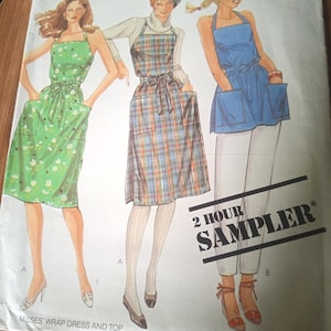 Può includere: Una busta di cartamodello McCall's per un vestito a portafoglio e un top, con illustrazioni di tre capi in stile grembiule: un vestito verde a fiori, un vestito a quadri con dolcevita e un top a grembiule blu con il testo 2 HOUR SAMPLER.