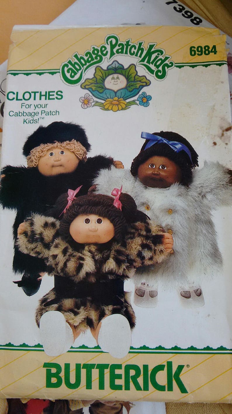 Pu&ograve; includere: Un modello di cucito vintage Cabbage Patch Kids per realizzare abiti per bambole. Il modello &egrave; per realizzare un cappotto di pelliccia nero, un cappotto di pelliccia bianco e un cappotto con stampa leopardata. Il numero del modello &egrave; 6984.