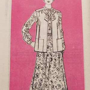 May include: A black and white line drawing of a woman wearing a long-sleeved blouse with a vest and a skirt with a paisley pattern. The drawing is on a pink background. The text "9279 - SIZE" is at the bottom of the image.
