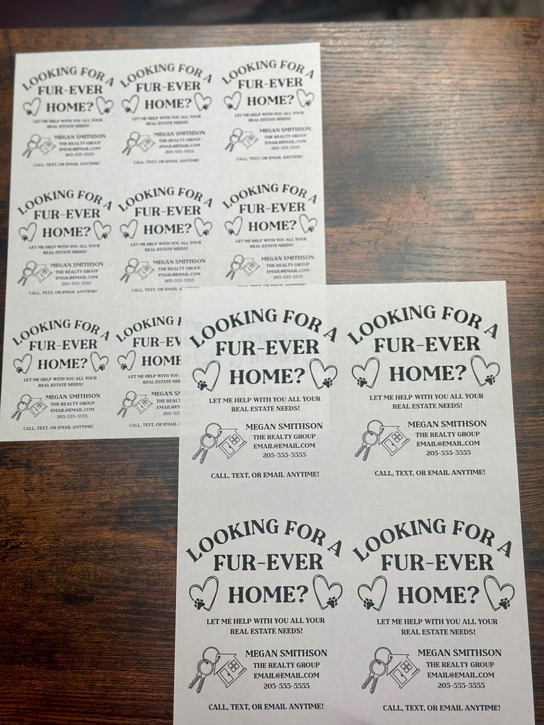 May include: Nine black and white flyers with the text "Looking for a Fur-Ever Home?" and a heart shape with a paw print inside. The flyers also include the text "Let me help with all your real estate needs!" and the name "Megan Smithson" with contact information for "The Realty Group".