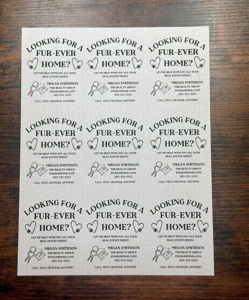 May include: Nine black and white business cards with a paw print and heart design. The text on the cards reads "Looking for a Fur-Ever Home? Let me help with you all your real estate needs! Megan Smithson The Realty Group Email@email.com 205-555-5555 Call, Text, or Email Anytime!"