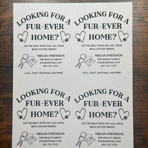 May include: Black and white business card with a paw print heart design. The text reads "Looking for a fur-ever home? Let me help with you all your real estate needs! Megan Smithson, The Realty Group, email@email.com, 205-555-5555, Call, text, or email anytime!"