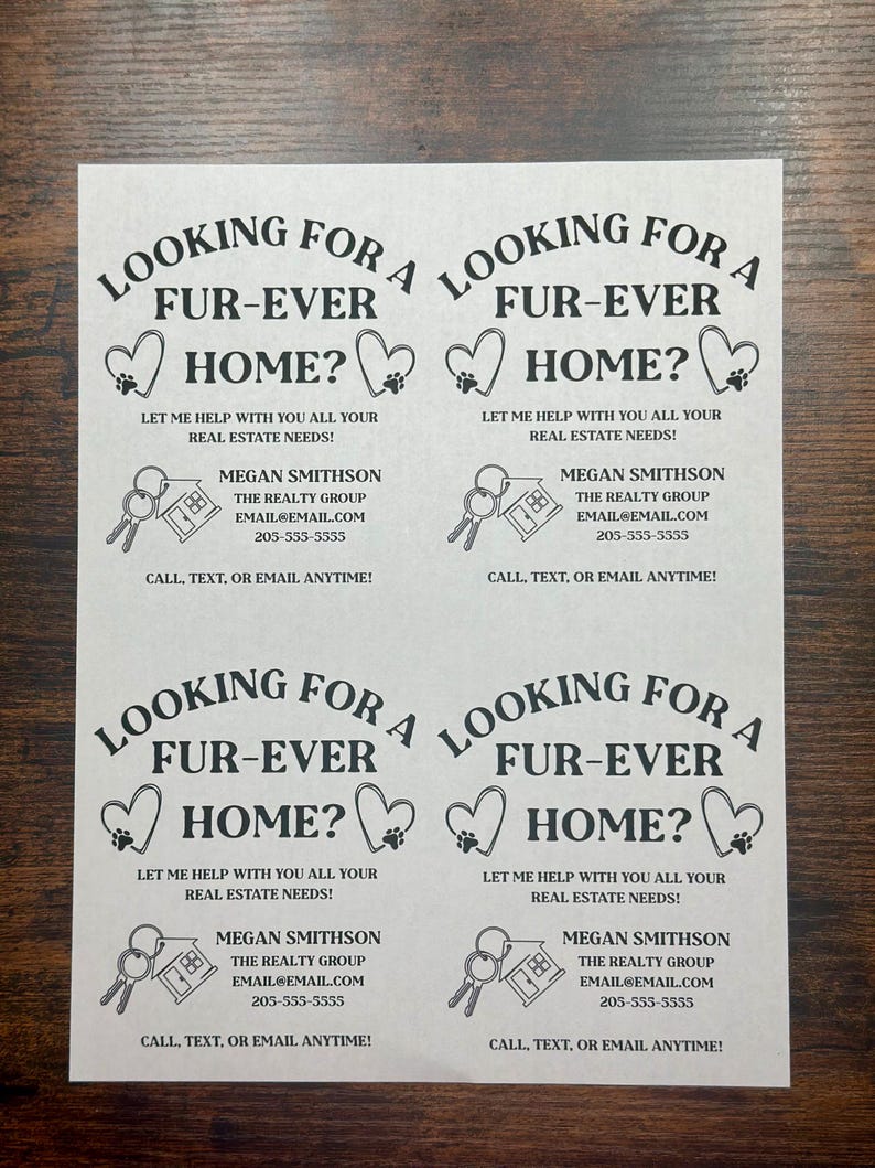 May include: Black and white business card with a paw print heart design. The text reads "Looking for a fur-ever home? Let me help with you all your real estate needs! Megan Smithson, The Realty Group, email@email.com, 205-555-5555, Call, text, or email anytime!"