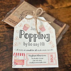 Peut inclure: Une étiquette blanche avec un motif de popcorn rouge et blanc et le texte "Just Popping by to say Hi!"  Appelez, envoyez un SMS ou un e-mail pour tous vos besoins en immobilier ! Meghan Khsytyne The Realty Group 208-555-5555 email@youremails.com VENDU