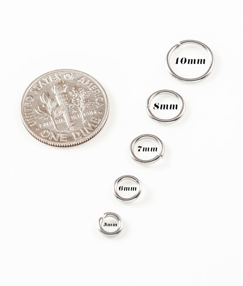 May include: Five silver jump rings in different sizes, ranging from 5mm to 10mm. The rings are arranged in a row from smallest to largest, with a US dime coin for scale.