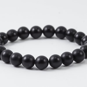 May include: A black beaded bracelet with round, matte beads.