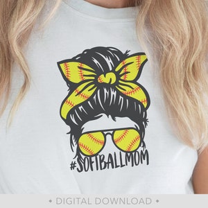 K&ouml;nnte beinhalten: Wei&szlig;es T-Shirt mit einer Grafik eines unordentlichen Dutt-Haarstils einer Frau, einer gelben Softball-Schleife und Sonnenbrille. Die Sonnenbrille ist so gestaltet, dass sie wie Softb&auml;lle aussieht. Der Text "#SOFTBALLMOM" steht darunter.