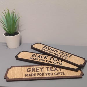 May include: Three wooden signs with rounded edges and a dark brown border. The signs have the text "BROWN TEXT MADE FOR YOU GIFTS", "BLACK TEXT MADE FOR YOU GIFTS", and "GREY TEXT MADE FOR YOU GIFTS" engraved in different colors.