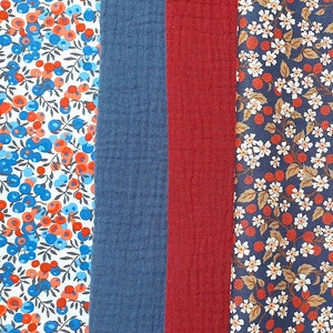 Può includere: Quattro campioni di tessuto, ognuno con un motivo diverso. Il primo campione è bianco con un motivo floreale blu e rosso. Il secondo campione è blu scuro tinta unita. Il terzo campione è rosso scuro tinta unita. Il quarto campione è blu scuro con un motivo floreale bianco.