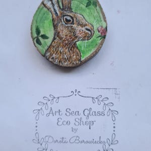 ミニチュアのウサギのペイントアート。スライスウッドに手描きされたウサギ。ウサギのペンダント。