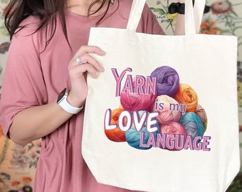 May include: A white tote bag featuring a colourful yarn design and the text "Yarn is my Love Language".