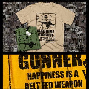 May include: Two t-shirts with a graphic design of a machine gun and the text "Death Dealer" and "Machine Gunner. Happiness is a belt fed weapon." The t-shirts are on a camouflage background.