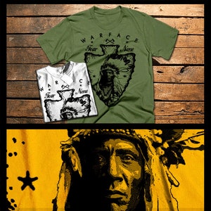 Può includere: Una maglietta verde con una grafica in bianco e nero di un guerriero nativo americano con copricapo. La grafica ha la forma di una punta di freccia e include il testo "WARFACE", "Fear None" e un simbolo di asce incrociate.
