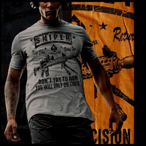 May include: A gray t-shirt with a black graphic of a rifle and the text "*SNIPER* Keep Calm - Return Fire" and "DON'T TRY TO RUN YOU WILL ONLY DIE TIRED."