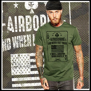 May include: A green t-shirt with a distressed graphic of a playing card. The card has a black spade, stars, and the text "War is Hell - Airborne - And when I get there I will arrive violently". The card also has a black and white American flag.