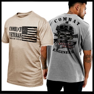 Puede incluir: Dos camisetas, una de color beige y otra gris. La camiseta beige tiene una bandera estadounidense en blanco y negro y el texto "Combat Veteran American Patriot". La camiseta gris tiene el texto "Combat Engineer" y una calavera con el texto "Deals in Death" en la parte posterior.