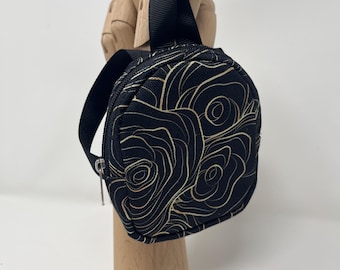 Tiny black/gold keychain backpack holds cards, keys, change, chapstick, iPods, etc. Attaches to backpack or belt loops with carabiner