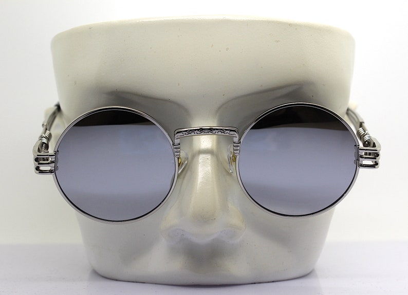 K&ouml;nnte beinhalten: Silberne runde Sonnenbrille mit verspiegelten Gl&auml;sern und filigranen Details an den B&uuml;geln.