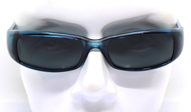 May include: Blue rectangular sunglasses with dark lenses. The frames have a glossy finish and a slight wrap-around design. The sunglasses are displayed on a white mannequin head.