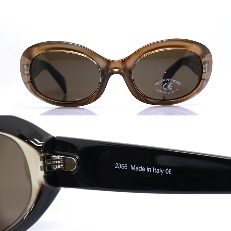 May include: Brown oval sunglasses with black arms and brown lenses. The sunglasses have a CE mark and the text "Optical Protection CE  CR39 UV Quality" on the right arm. The sunglasses also have the text "2366 Made in Italy CE" on the inside of the left arm.