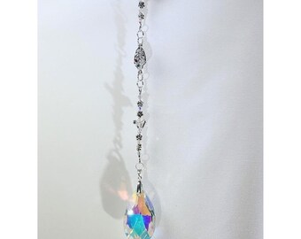 May include: A silver chain with small decorative charms hangs from a teardrop-shaped crystal prism that has iridescent rainbow colors.