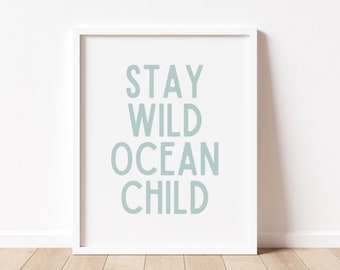 May include: White framed print with the text "Stay Wild Ocean Child" in light blue.