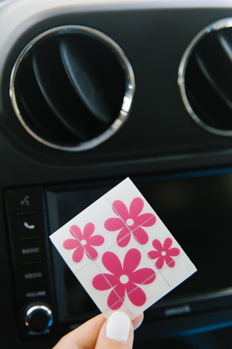 May include: A sheet of pink flower stickers with white centers. The stickers are on a white background and are arranged in a grid pattern.