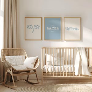 Puede incluir: Tres láminas enmarcadas con temática de carreras. Las láminas presentan un par de banderas a cuadros, el texto "LITTLE RACER DUDE" y un coche de carreras, todo en azul claro. Los marcos son de color madera clara y el fondo es neutro.