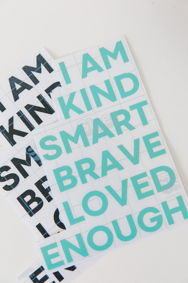 May include: A sheet of white vinyl with turquoise lettering that reads "I am kind smart brave loved enough".