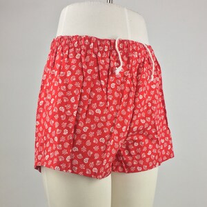 May include: Red shorts with a white seashell pattern.