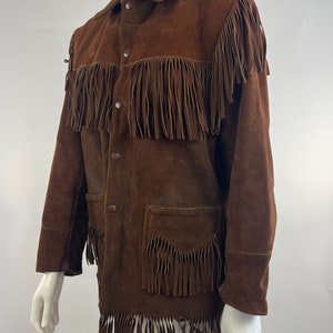 May include: A brown suede jacket with fringe detailing. The jacket has a button-up front and two pockets.