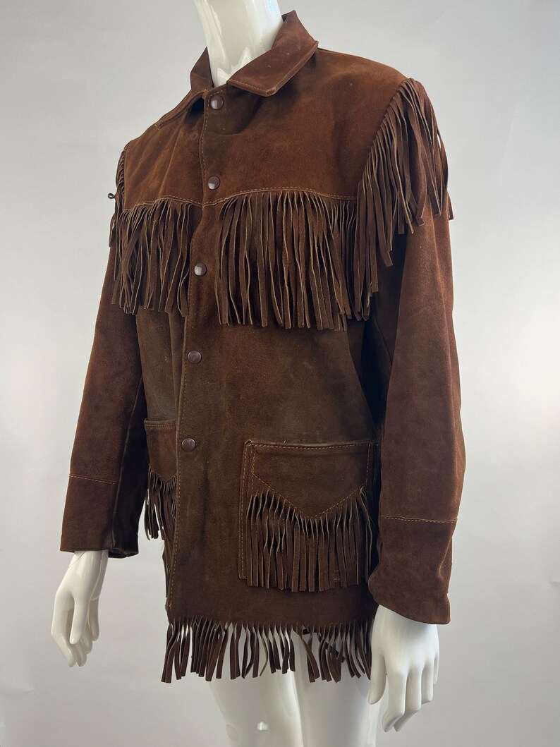 May include: A brown suede jacket with fringe detailing. The jacket has a button-up front and two pockets.